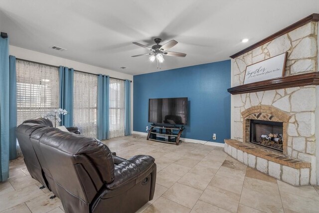 living room with light tile patterned floors, a fireplace, and ceiling fan