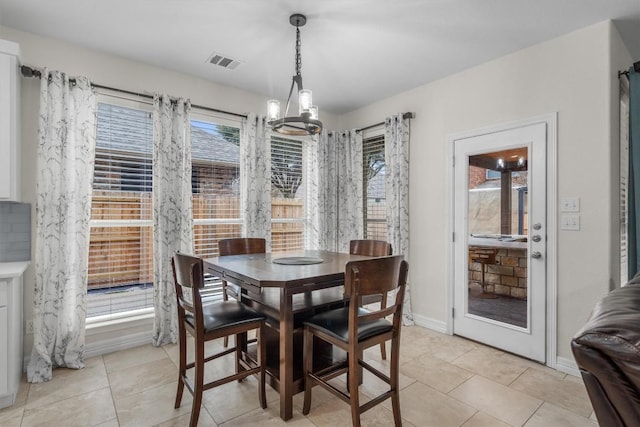 dining space with visible vents, baseboards, a notable chandelier, and light tile patterned flooring