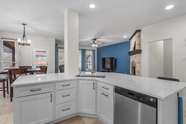 kitchen with sink, white cabinetry, dishwasher, pendant lighting, and ceiling fan with notable chandelier