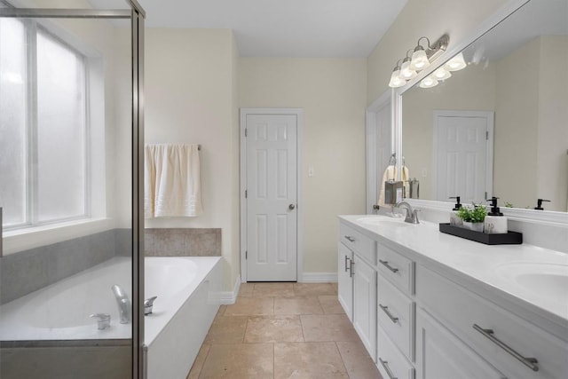 full bathroom with a bath, a healthy amount of sunlight, double vanity, and a sink