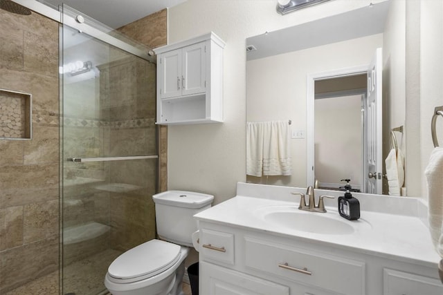 full bathroom featuring visible vents, a stall shower, toilet, and vanity