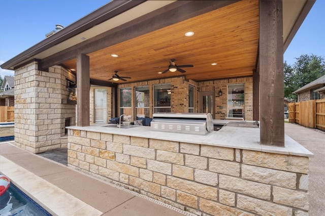 view of patio / terrace featuring an outdoor kitchen, ceiling fan, fence, and a grill