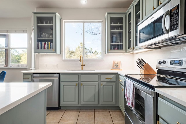 kitchen with stainless steel appliances, sink, backsplash, and gray cabinets