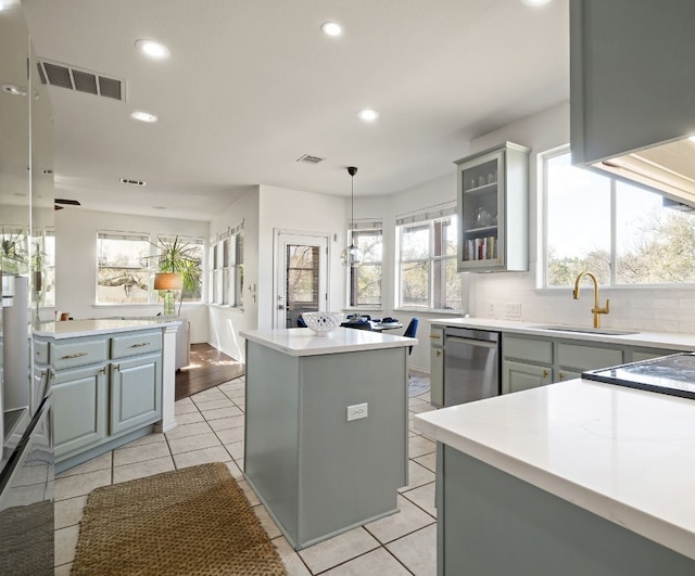 kitchen featuring gray cabinetry, sink, a center island, and dishwasher