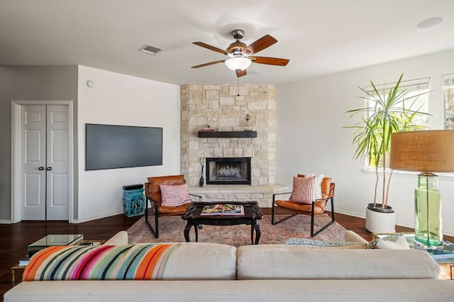 living room with dark wood-type flooring, ceiling fan, and a fireplace