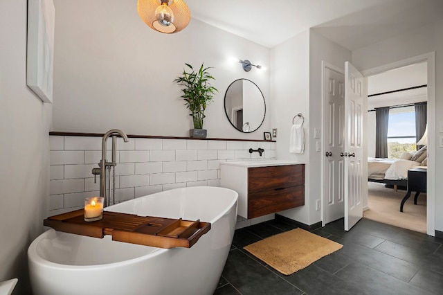 bathroom with vanity, a tub to relax in, tile patterned flooring, and tile walls