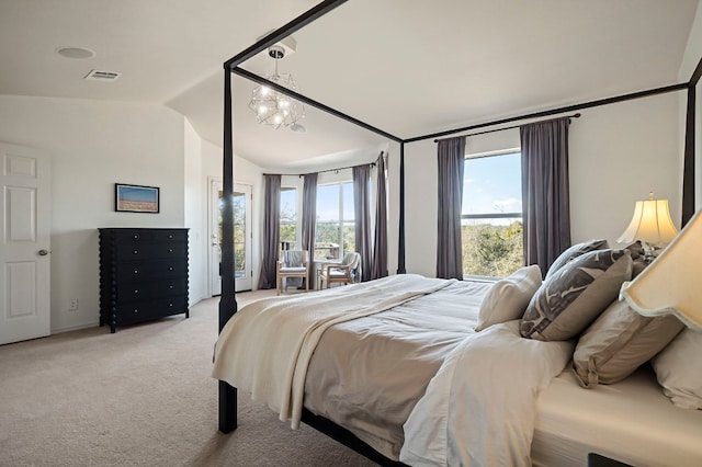 carpeted bedroom with an inviting chandelier, vaulted ceiling, and multiple windows