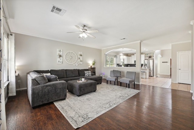 living room with hardwood / wood-style flooring, ornamental molding, and ceiling fan