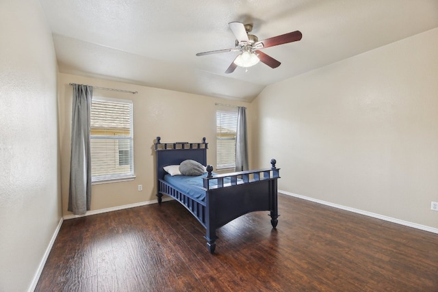 bedroom with dark hardwood / wood-style flooring, vaulted ceiling, and ceiling fan