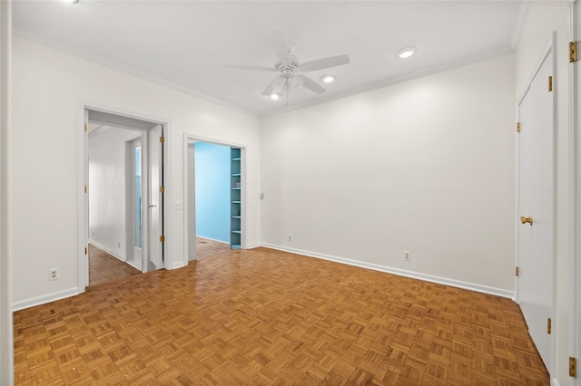 spare room with parquet floors, ceiling fan, and crown molding