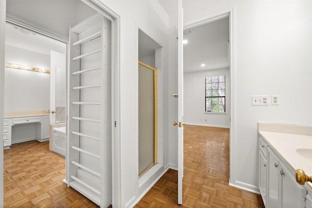 bathroom with vanity, parquet flooring, and a shower with door