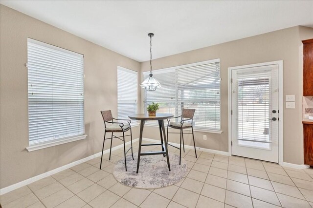 dining area featuring light tile patterned floors and an inviting chandelier