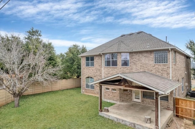 back of house with a lawn and a patio area