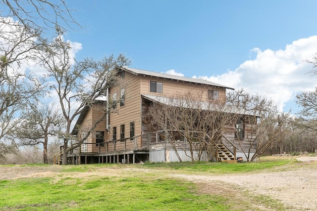 view of home's exterior with a wooden deck and a yard