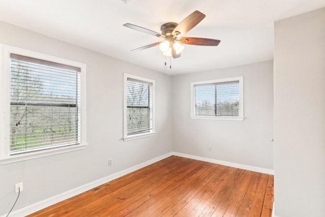 empty room with ceiling fan, wood-type flooring, and plenty of natural light