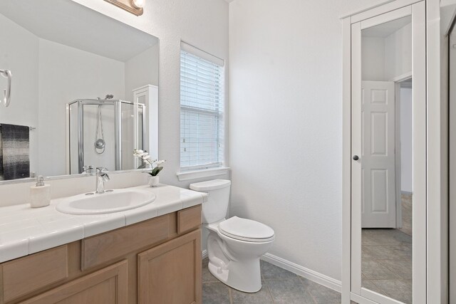 bathroom featuring vanity, plenty of natural light, a shower with door, and toilet