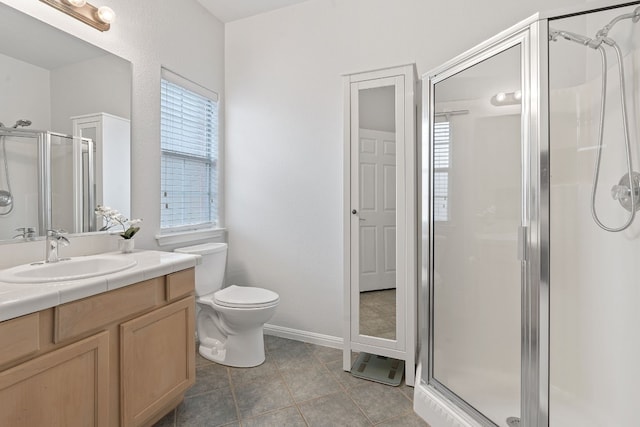 bathroom with tile patterned flooring, vanity, toilet, and a shower with shower door