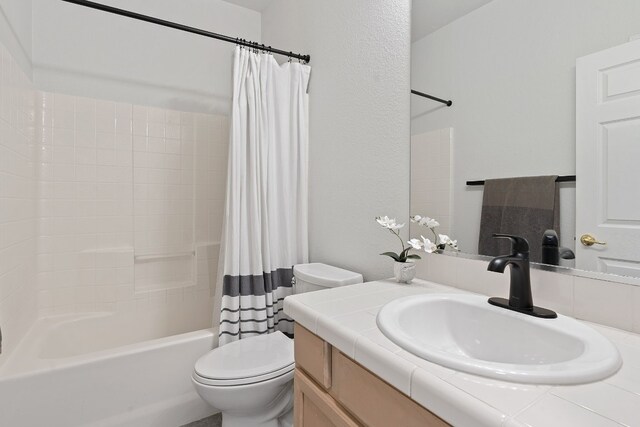 full bathroom with vanity, shower / bathtub combination with curtain, and toilet