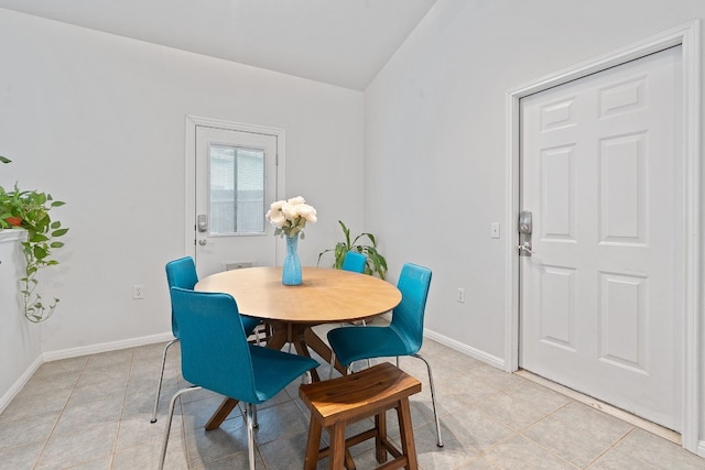 tiled dining room with vaulted ceiling