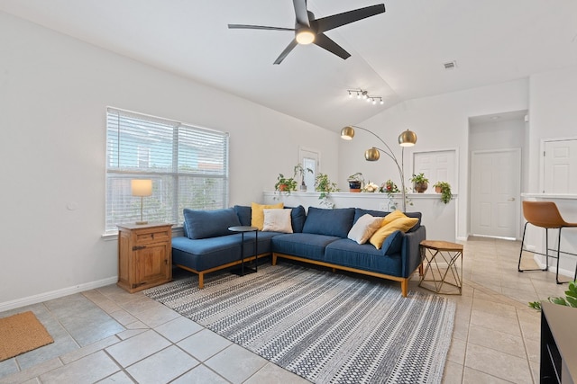 living room featuring light tile patterned flooring, visible vents, baseboards, vaulted ceiling, and a ceiling fan