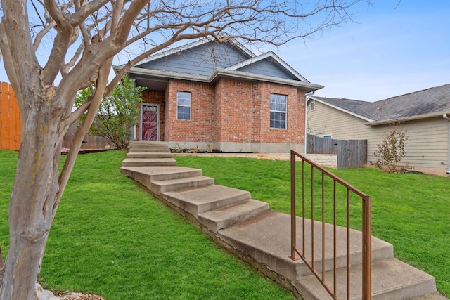 view of front of house featuring a front yard, brick siding, and fence