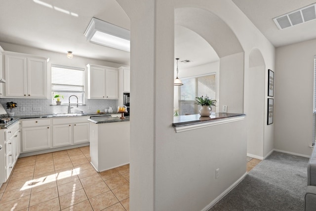 kitchen featuring tasteful backsplash, sink, and white cabinets