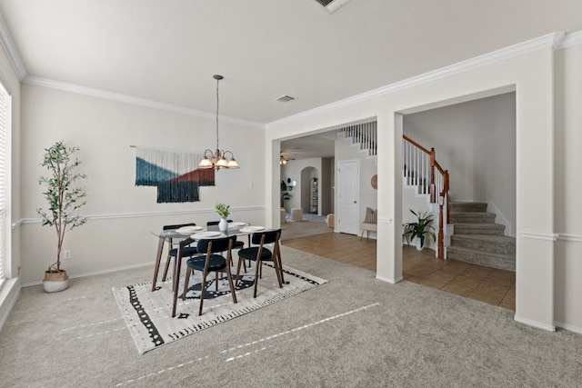 dining space with an inviting chandelier, crown molding, and light colored carpet