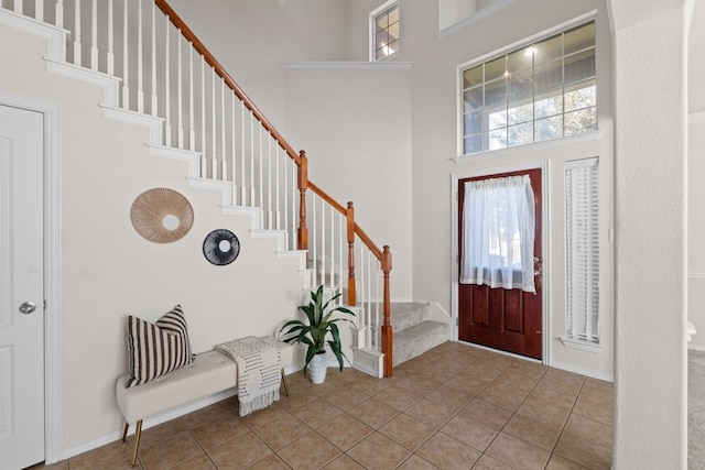 foyer with light tile patterned floors and a high ceiling