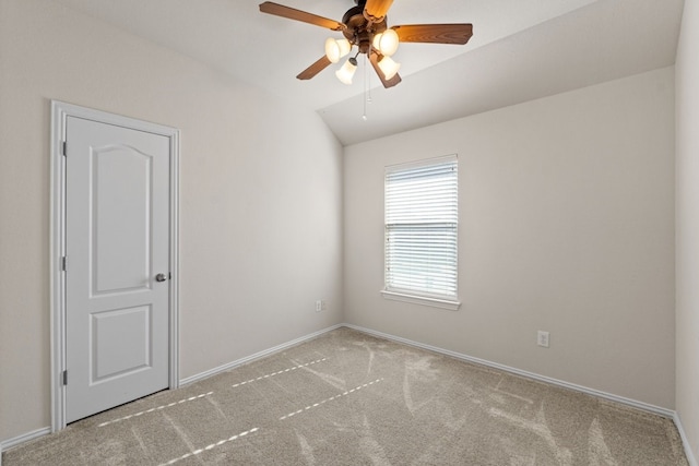 spare room with ceiling fan, lofted ceiling, and light carpet