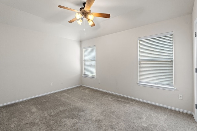 carpeted spare room with ceiling fan and vaulted ceiling