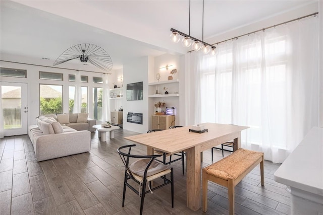 dining space featuring wood-type flooring and built in shelves