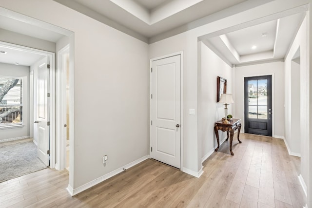 foyer featuring light hardwood / wood-style floors and a raised ceiling