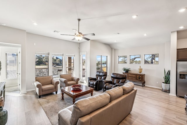 living room featuring light hardwood / wood-style flooring, ceiling fan, and vaulted ceiling