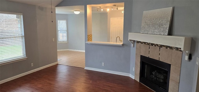 unfurnished living room with dark hardwood / wood-style flooring and a fireplace