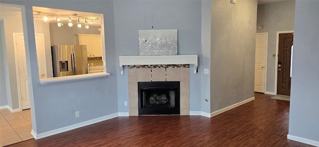 unfurnished living room with hardwood / wood-style flooring and a tile fireplace