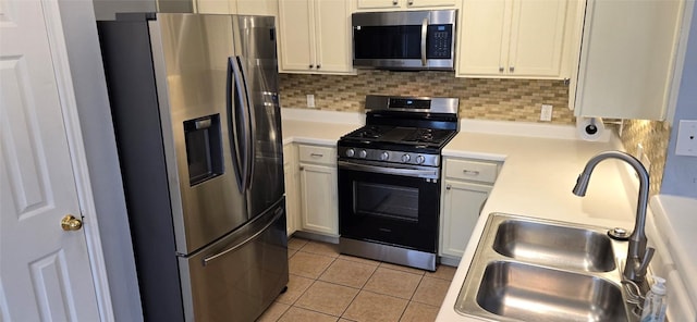 kitchen featuring white cabinetry, sink, light tile patterned flooring, and appliances with stainless steel finishes