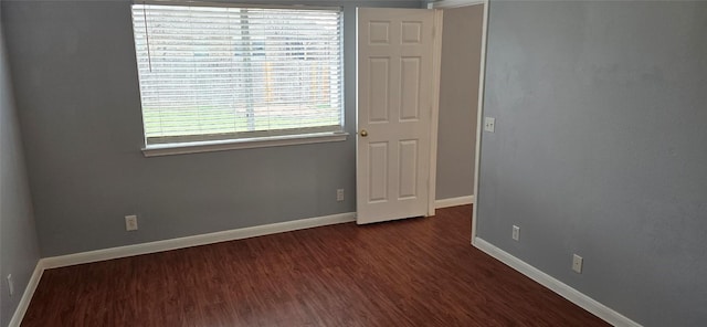 spare room with dark hardwood / wood-style flooring