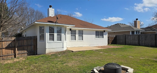 back of house featuring a lawn and a patio area