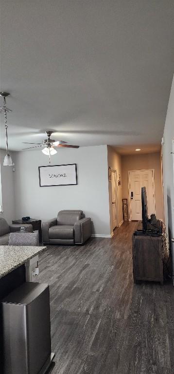 living room featuring dark wood-style floors and ceiling fan