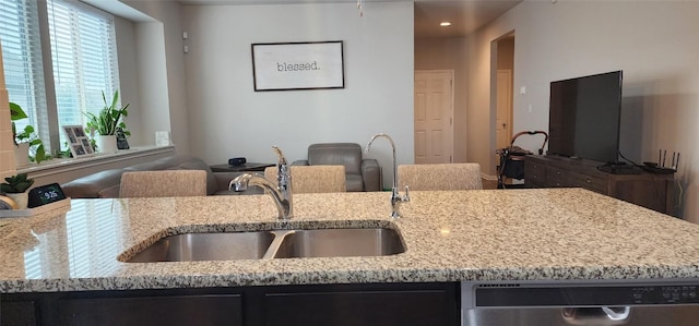 kitchen featuring a sink, light stone counters, dishwasher, and recessed lighting