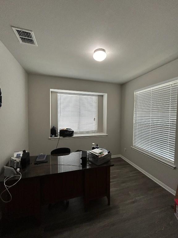 home office featuring dark wood-type flooring, visible vents, and baseboards