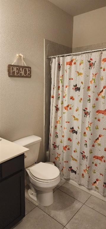 bathroom featuring toilet, vanity, shower / tub combo with curtain, and tile patterned floors