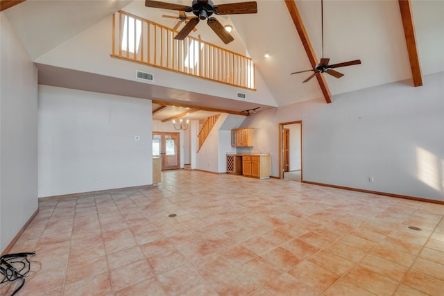 unfurnished living room featuring beam ceiling, ceiling fan with notable chandelier, and high vaulted ceiling