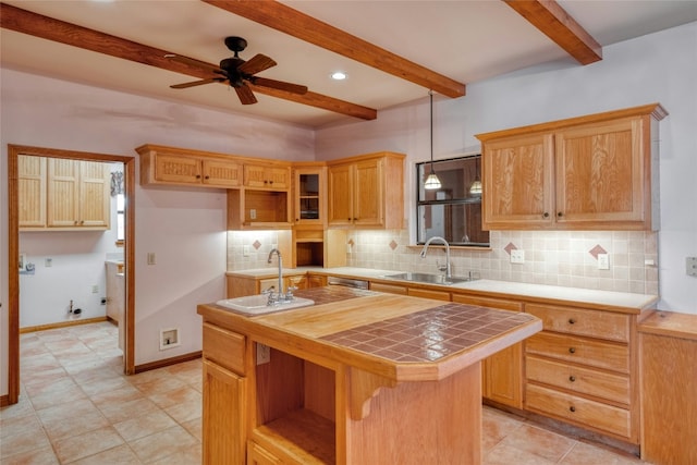 kitchen with a center island, sink, tile countertops, and pendant lighting