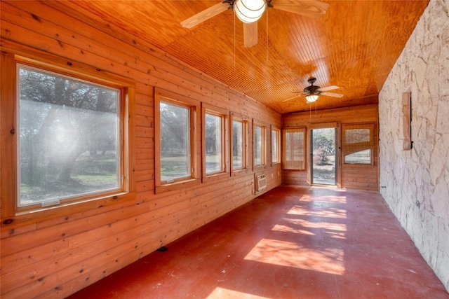 unfurnished sunroom featuring a wall unit AC, wooden ceiling, and ceiling fan