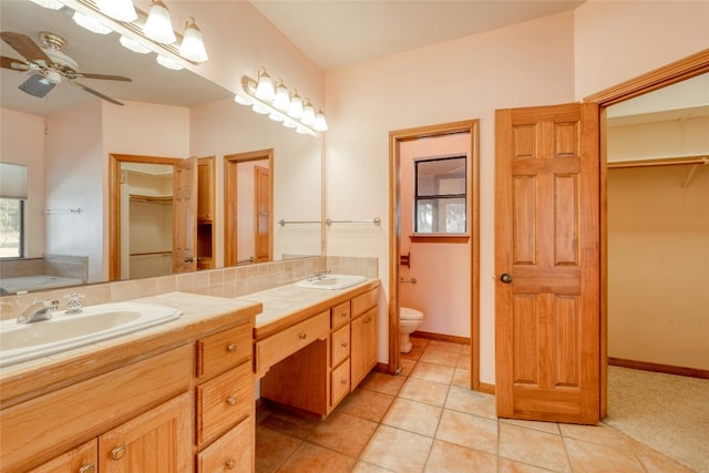 bathroom with toilet, vanity, a bathtub, ceiling fan, and tile patterned flooring