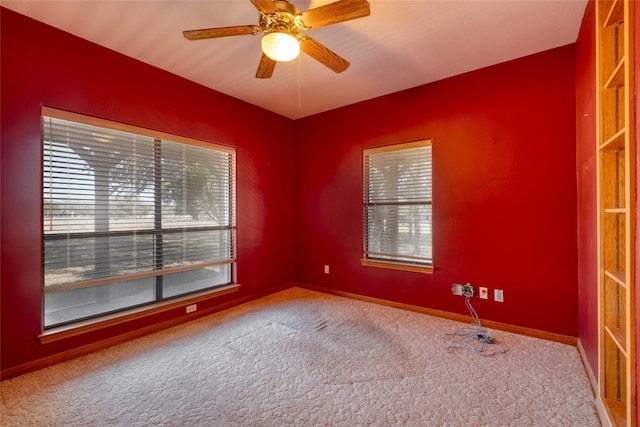 carpeted spare room with ceiling fan and a wealth of natural light