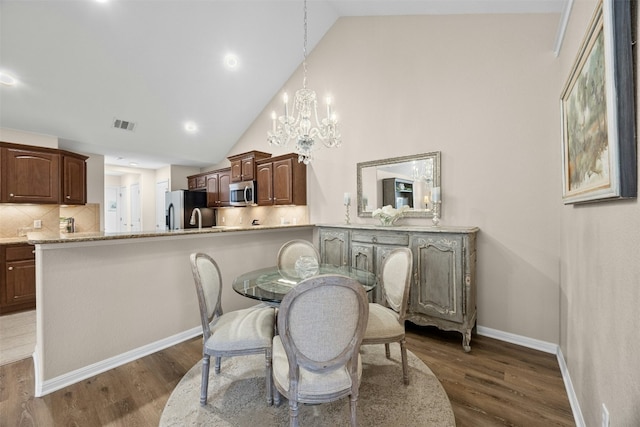 30 Wildwood Dr Unit 41, Georgetown, TX 78633 - dining area with a chandelier, dark wood finished floors, baseboards, and high vaulted ceiling