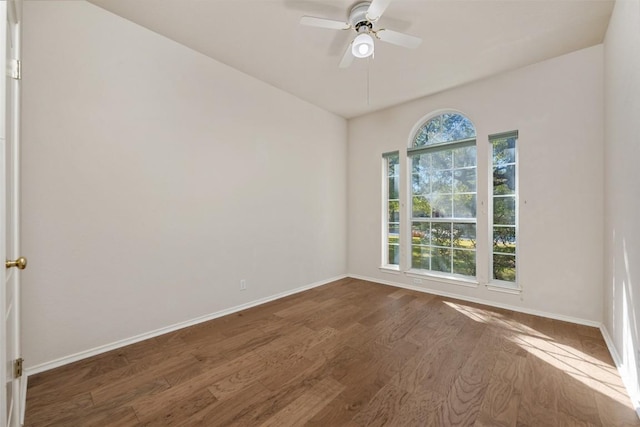 spare room with ceiling fan, plenty of natural light, and dark hardwood / wood-style floors