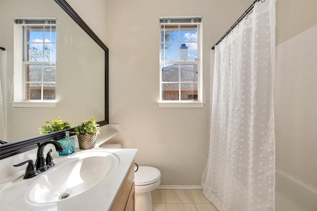 bathroom with vanity, toilet, tile patterned flooring, and a wealth of natural light